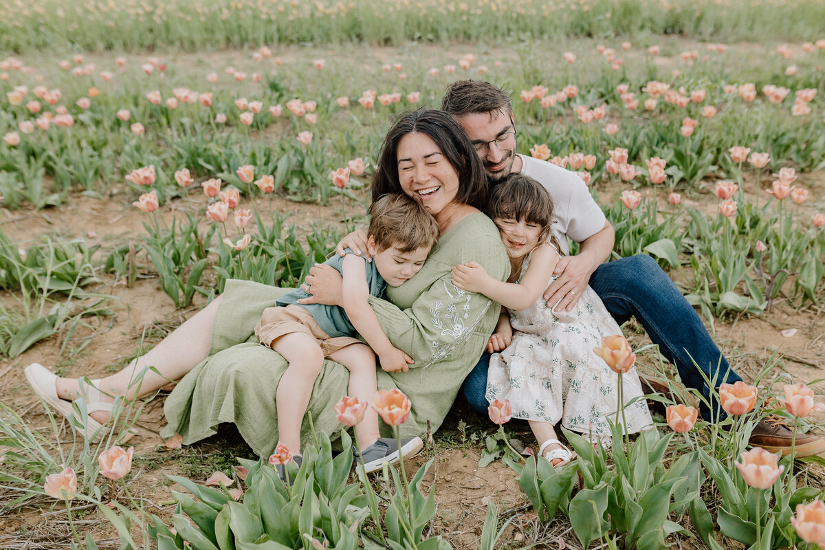 A family with two kids sits in the tulip fields and poses for their family photos at the Midwest Tulip Festival in Illinois.