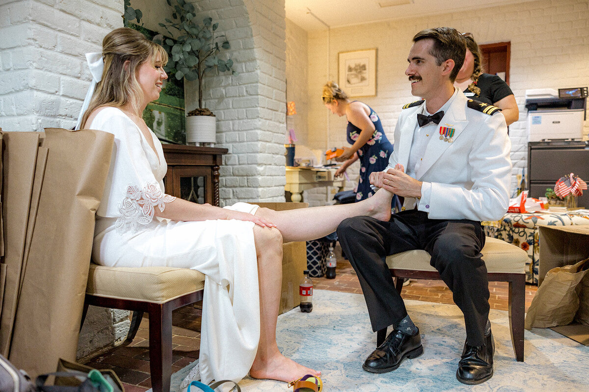 Groom rubbing bride's feet on their wedding day