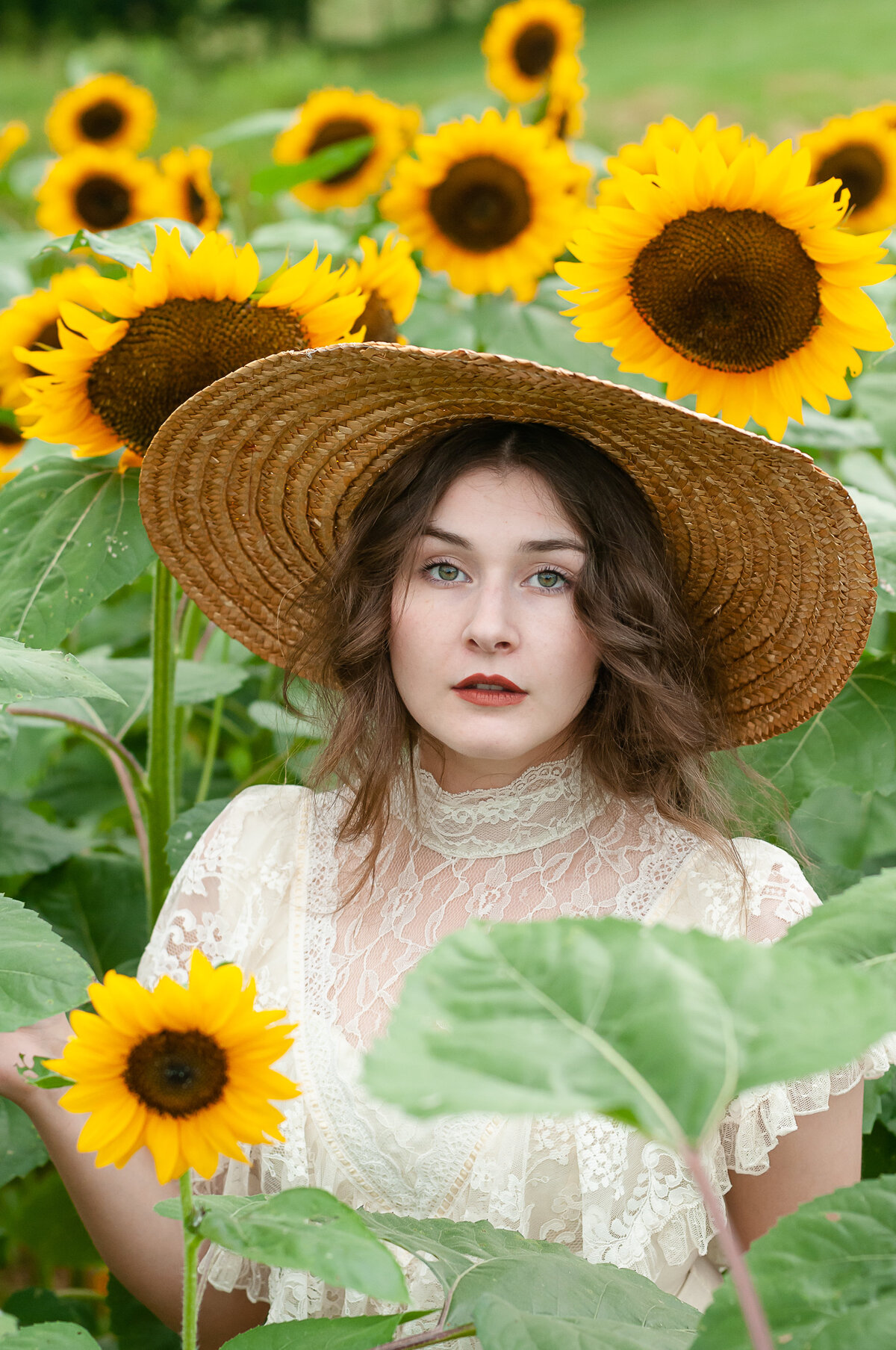 Kentucky Sunflower Photographer: Portrait of a woman in a sunflower field wearing a hat.