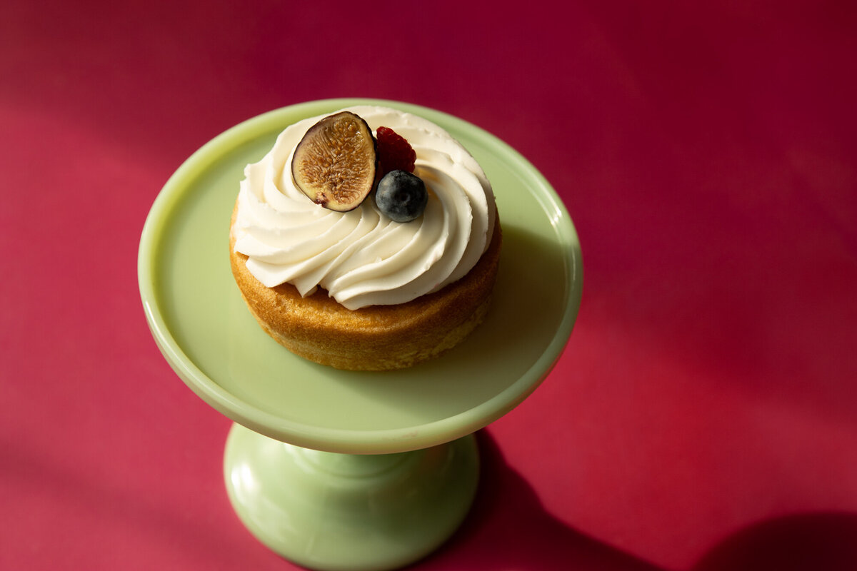 Lemon cake, with Chantilly cream with fresh fruits on pink background