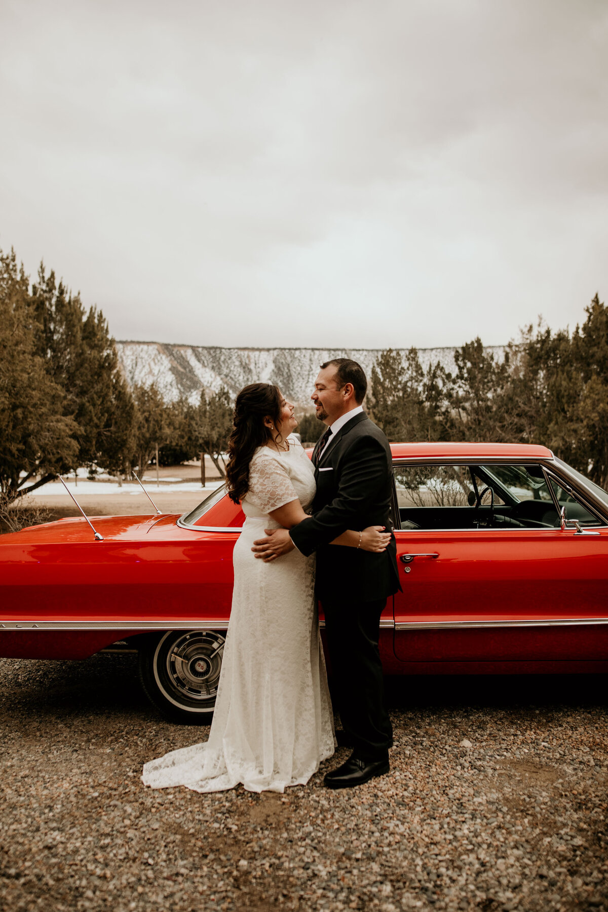 bride and groom standing in front of 1963 Cadillac