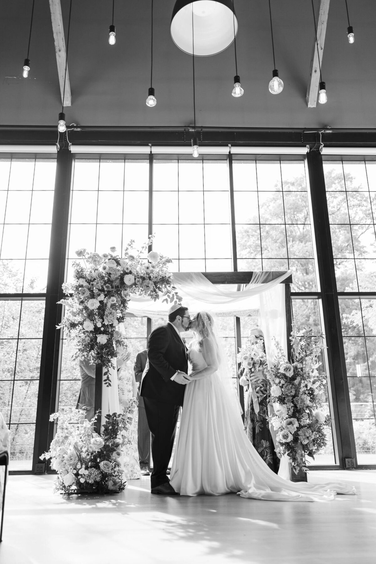 Indoor ceremony photo from The Roundhouse with bride and groom kissing