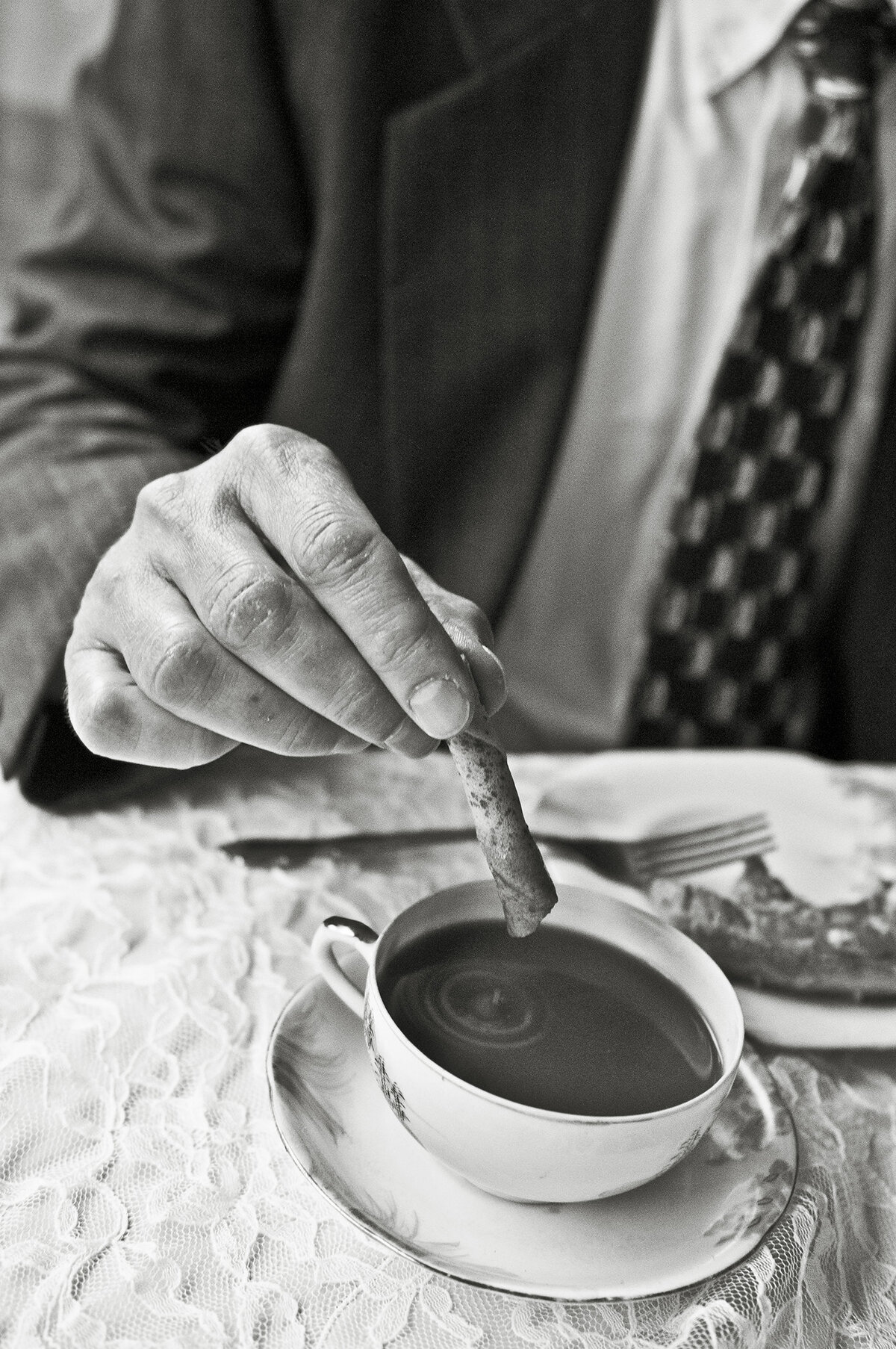 A person dipping biscotti in a cup of coffee