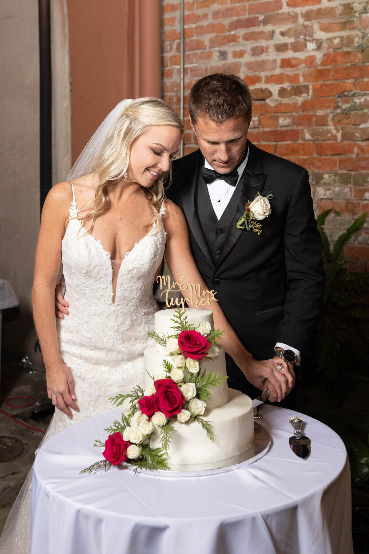 The new couple cuts the cake at their wedding reception in New Orleans, Louisiana at the Pharmacy Museum.