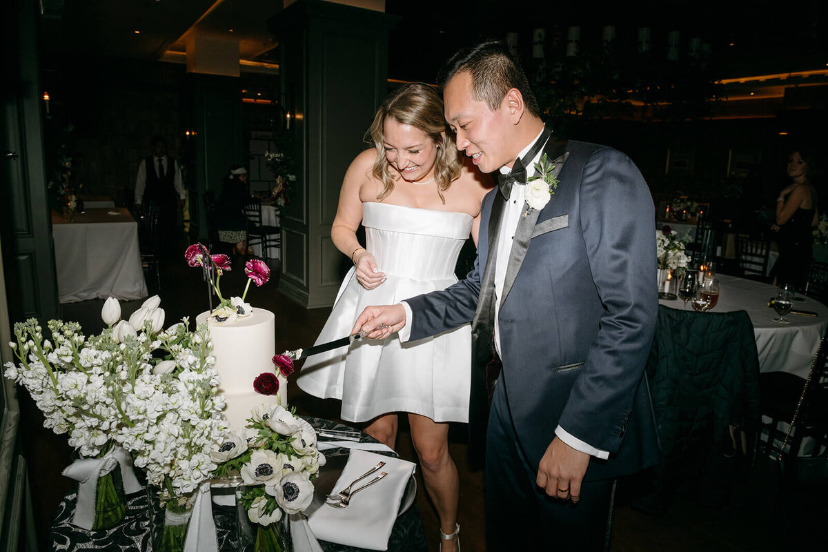 Bride and Groom cur their cake with guests looking on at their St. Regis Aspen wedding reception.
