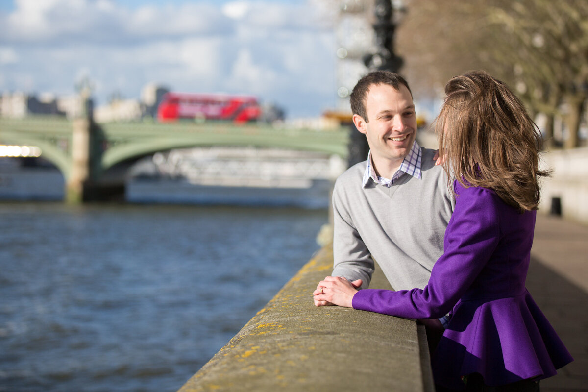 Woman in purple jacket talking with boyfriend by river
