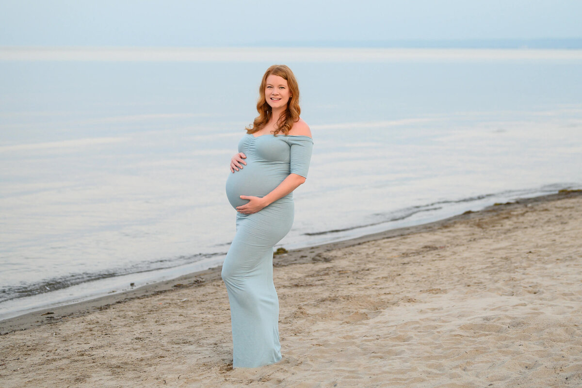 pregnant woman with the lake behind her for her beach maternity photos 