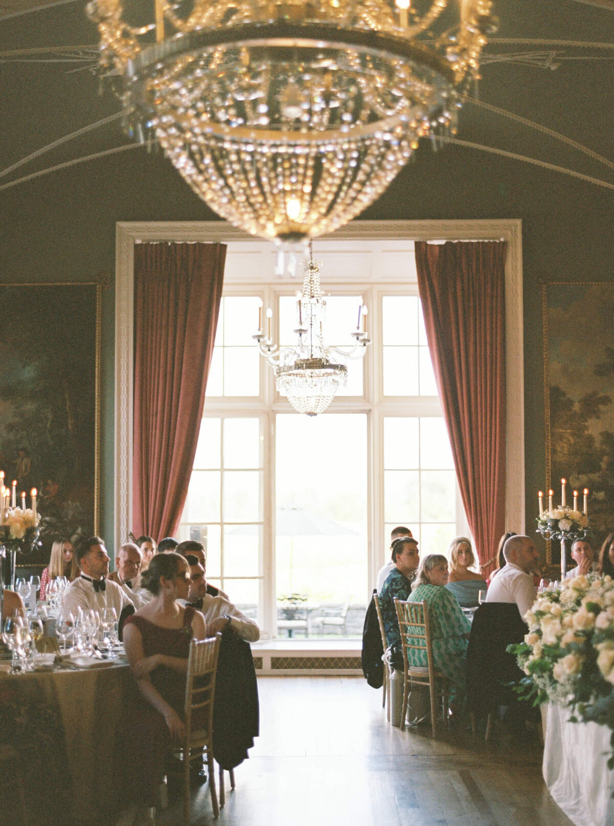 A wedding photo of guests sitting for dinner in the reception hall in Luttrellstown Castle
