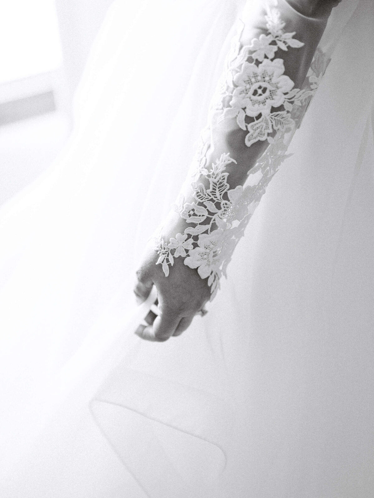 Bride's lace wedding dress sleeve in soft lighting