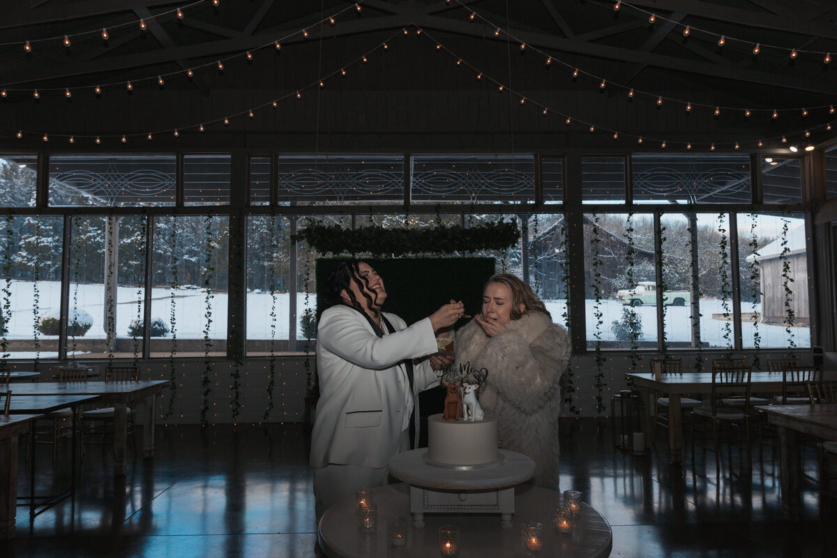 Newlyweds feed each other cake at their LGBTQ elopement 