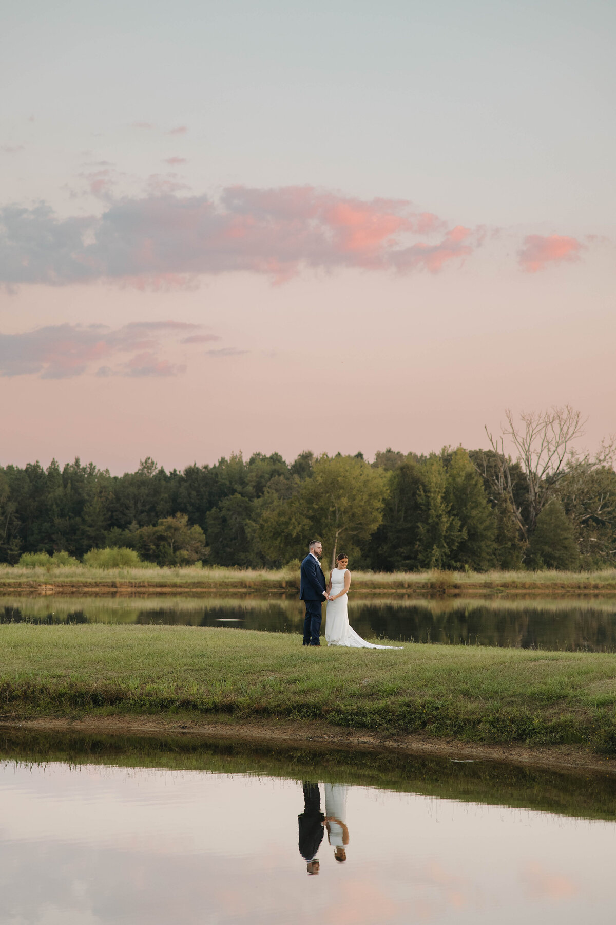 bride and groom on a lake at sunset