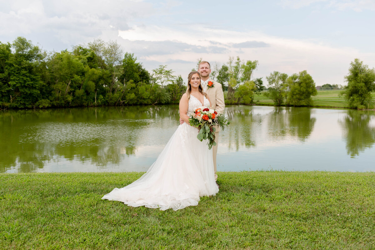 Romantic Mr. and Mrs. portraits captured by Style & Grace Photography at a serene lake in Waterloo, IL, showcasing the newlyweds' love amidst a tranquil and scenic setting.