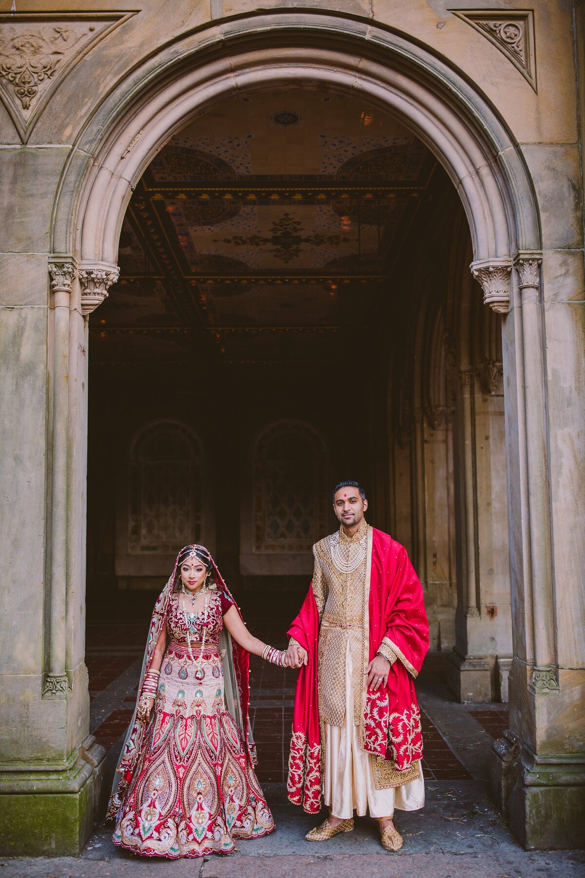 Indian bride and groom standing under the arch at central park bethesda terrace