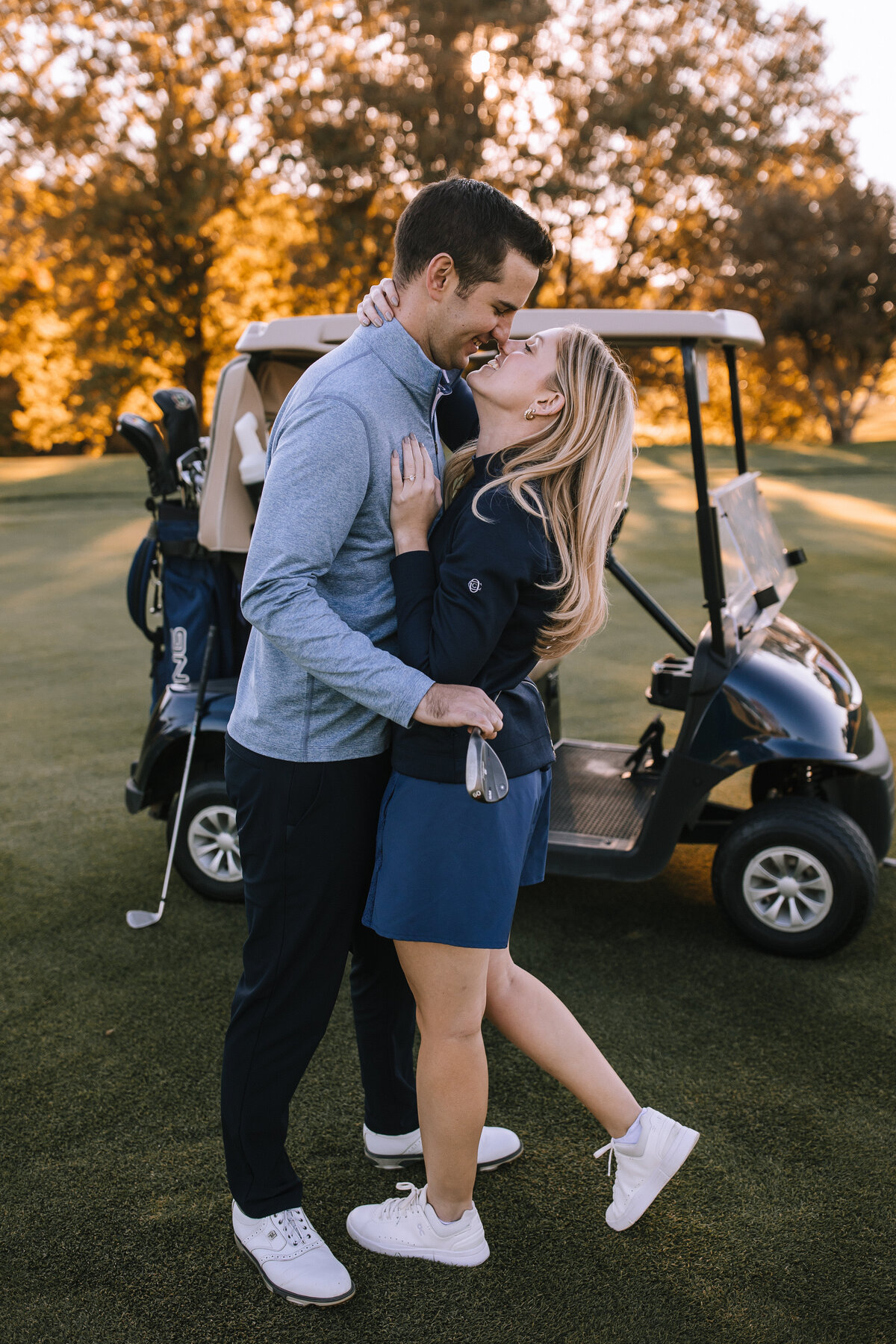 Engaged couple by a golf cart  at Longue Vue Country Club.