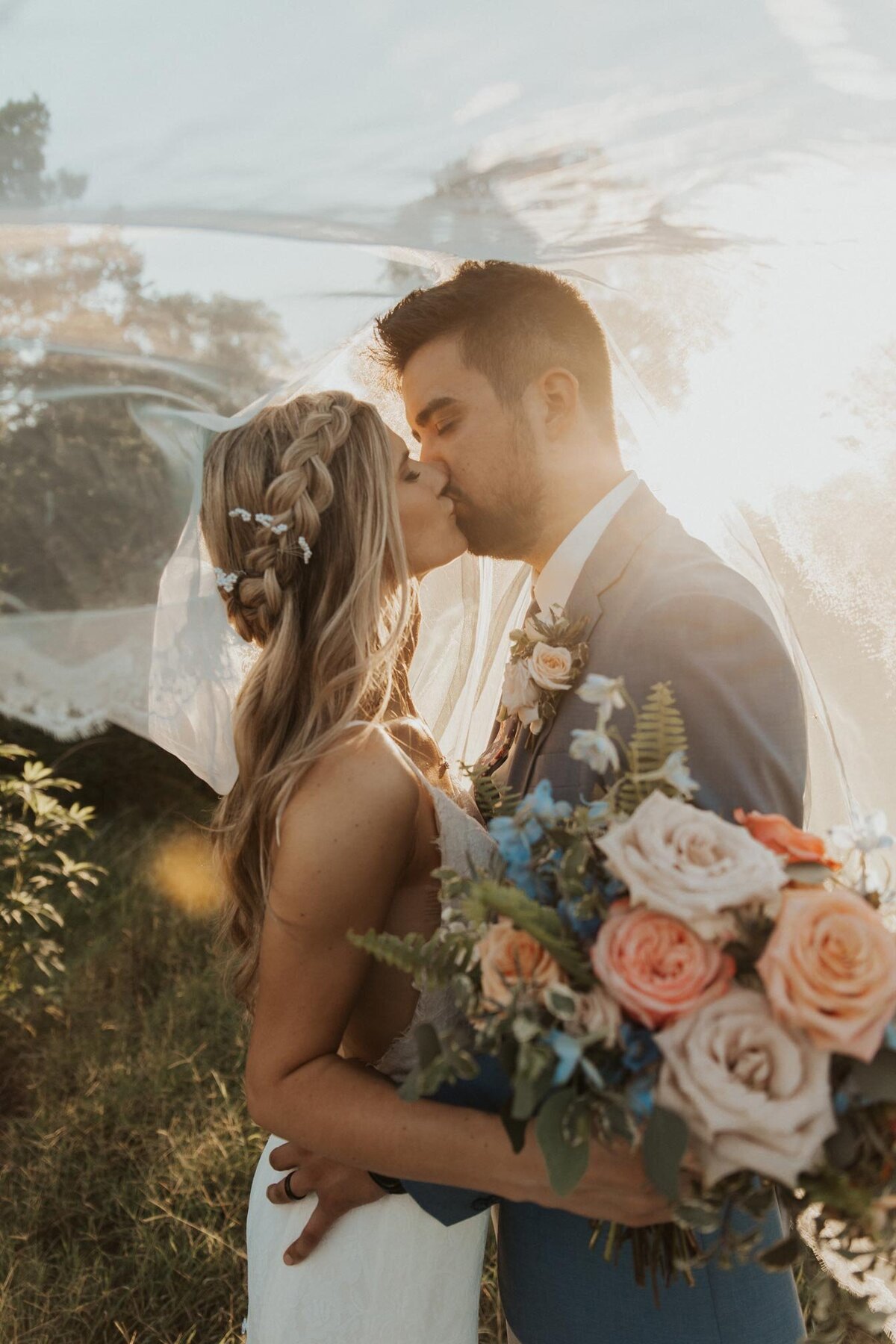 bride-groom-kissing-wedding-gown-bouquet