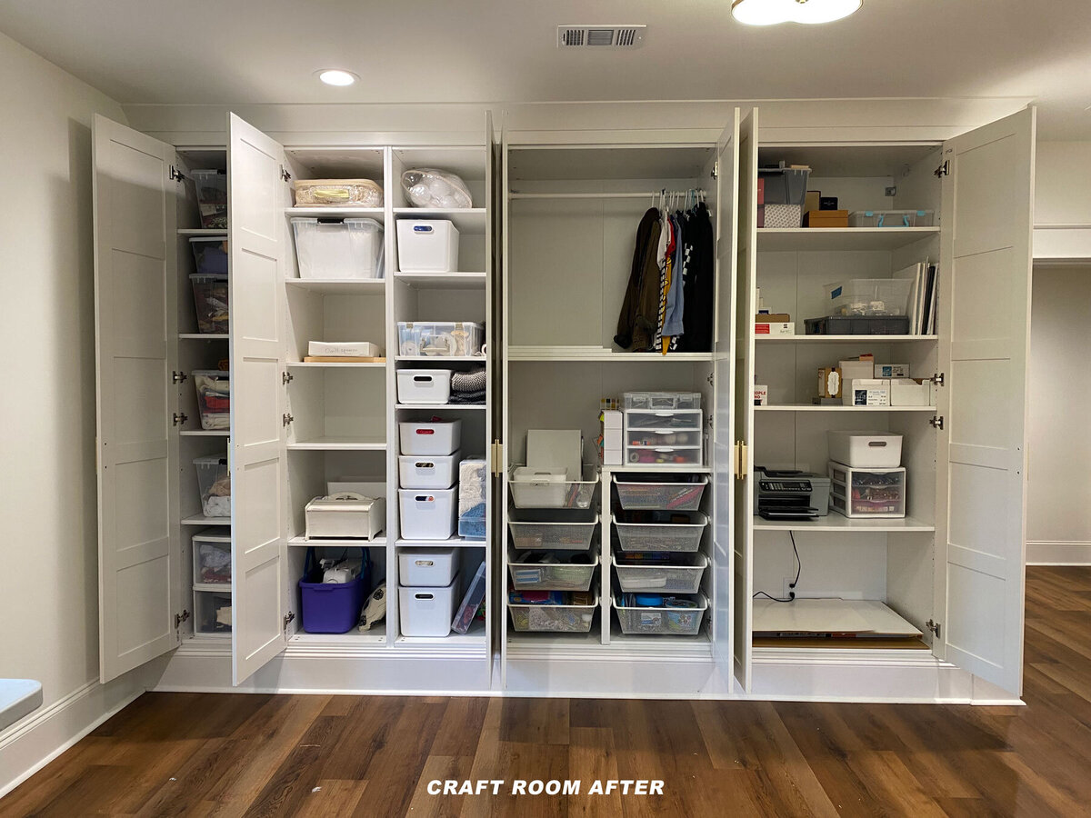 Organized craft room closet with open white cabinets displaying neatly arranged supplies in transparent bins. Shelves hold folded fabrics, art materials, and tools. The floor is hardwood, and overhead lighting illuminates the space. Text reads "Craft Room After.