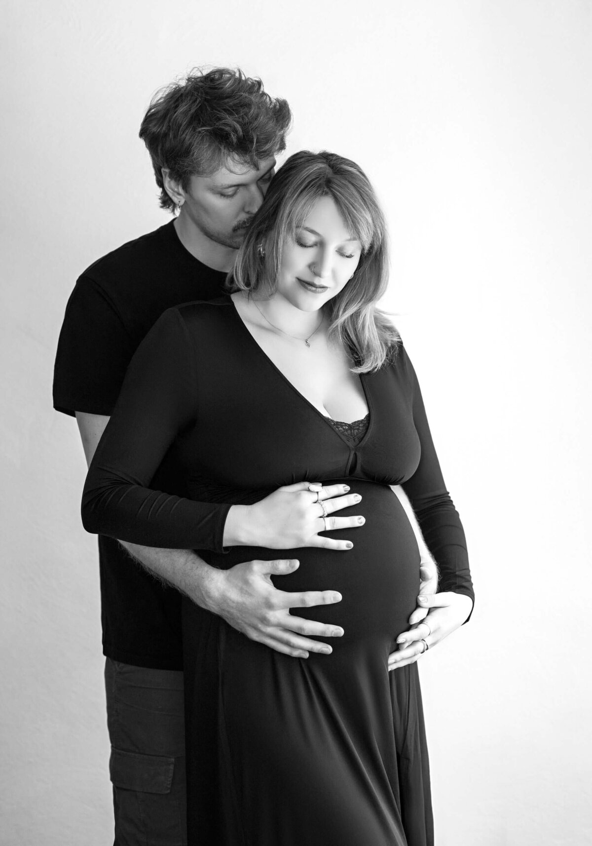 Intimate maternity couple embrace.