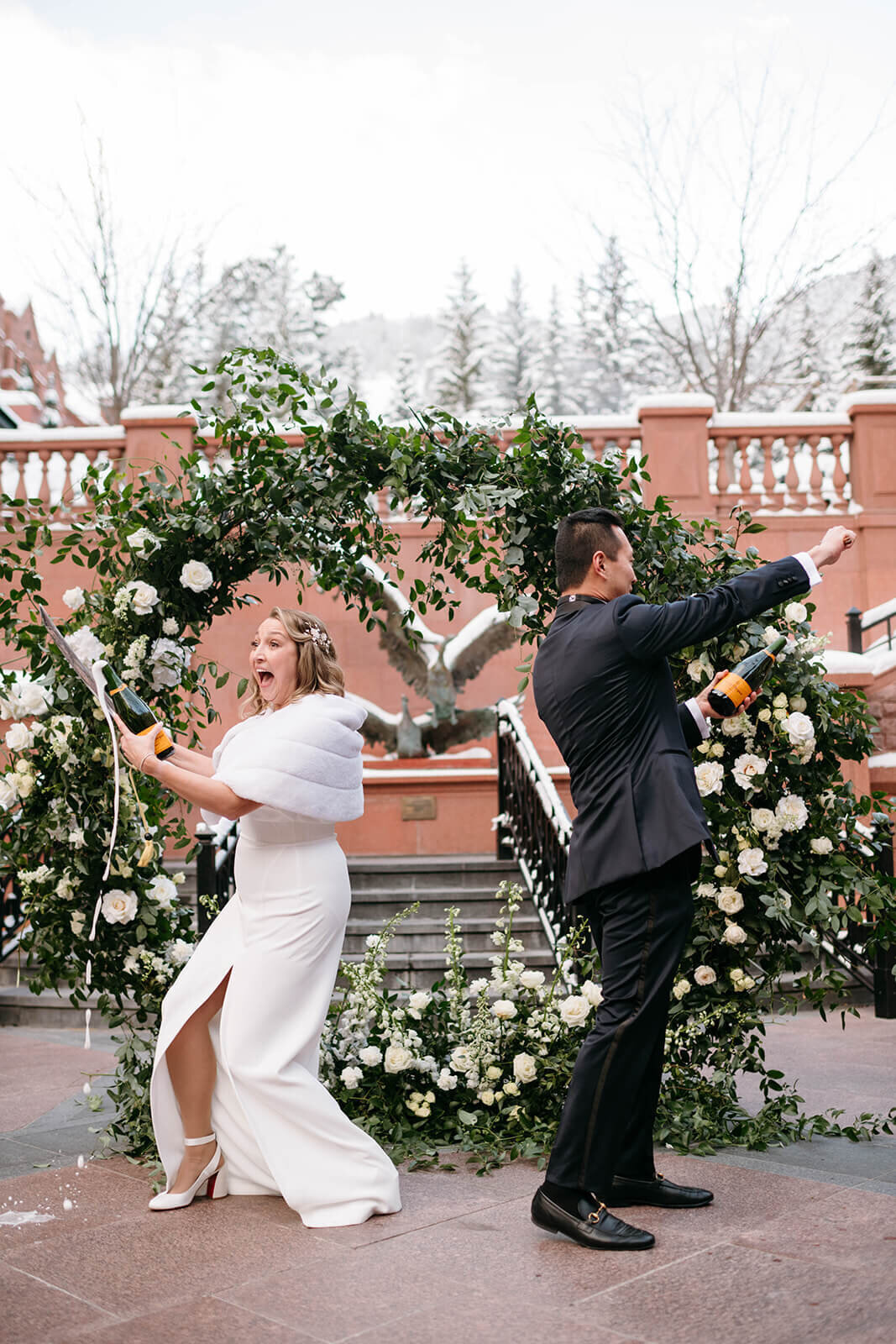 bride and groom popping champagne