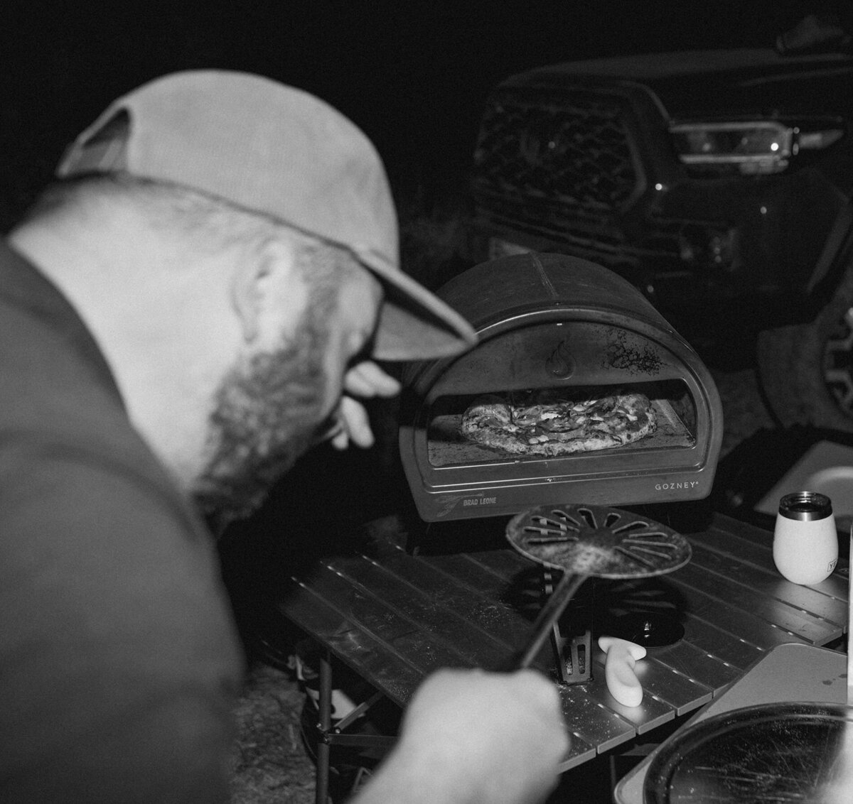 a man cooks meals on a grill while camping at an elopement in Moab, Utah