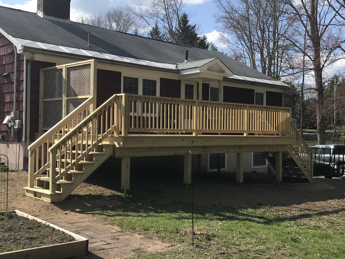 View of a PT wood deck with two sets of stairs and wooden trellis privacy fence