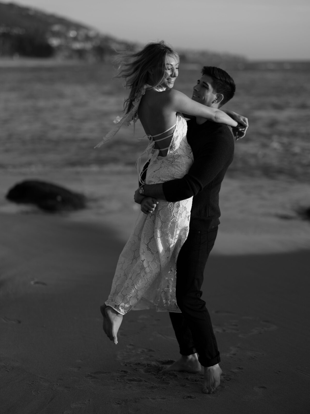 Man picking up his girl during engagement shoot in Laguna Beach