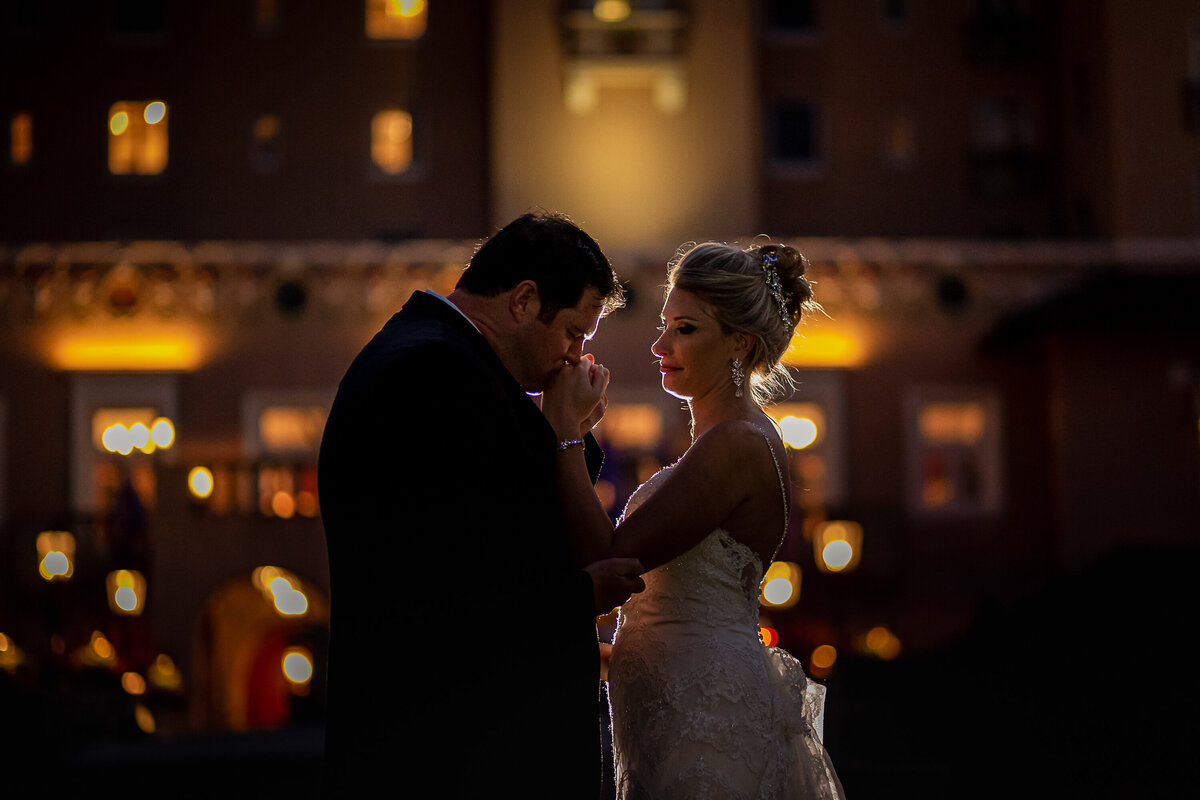 Bride and Groom pose at night with the Broadmoor as a backdrop