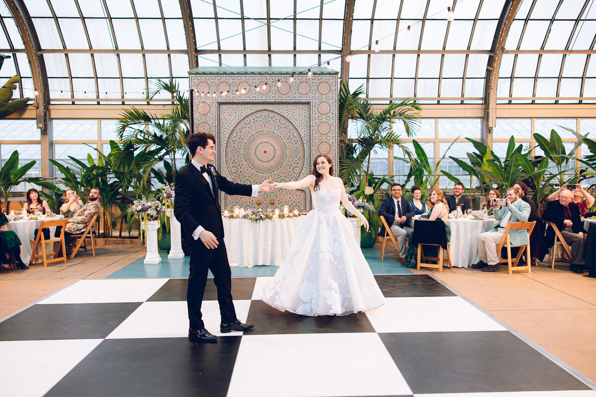 A couple shares their first dance at their wedding at the Garfield Park Conservatory in Chicago