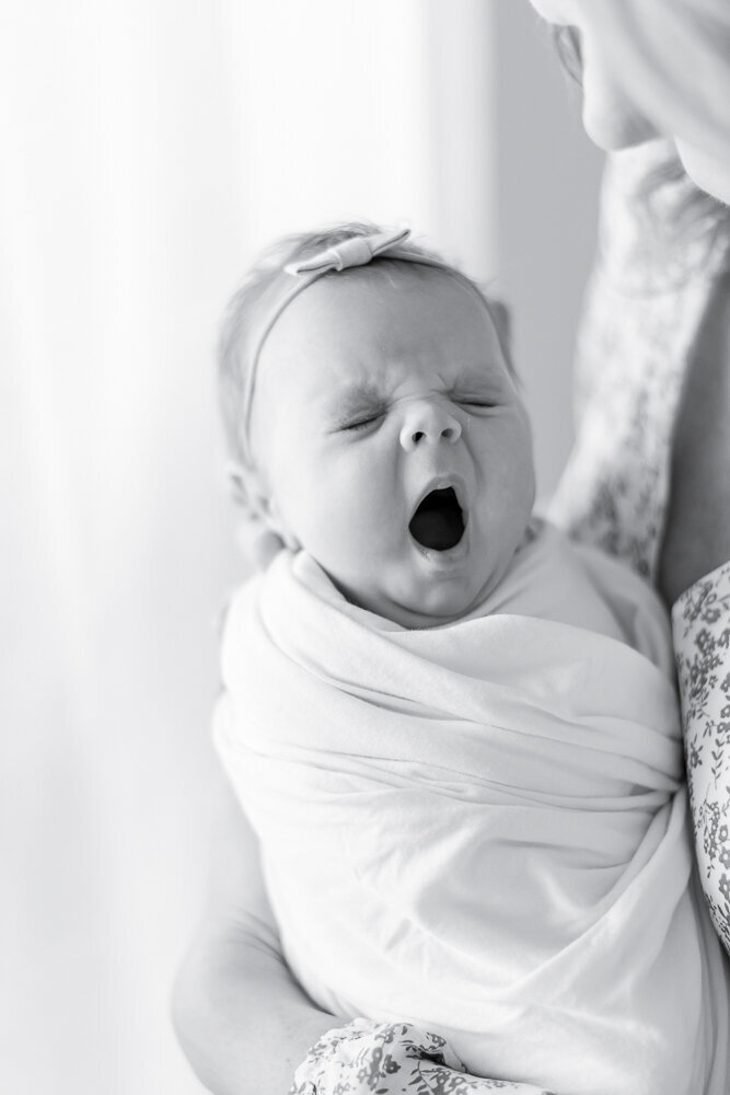 Black and white image of a newborn yawning in kristie lloyd's nashville photography studio