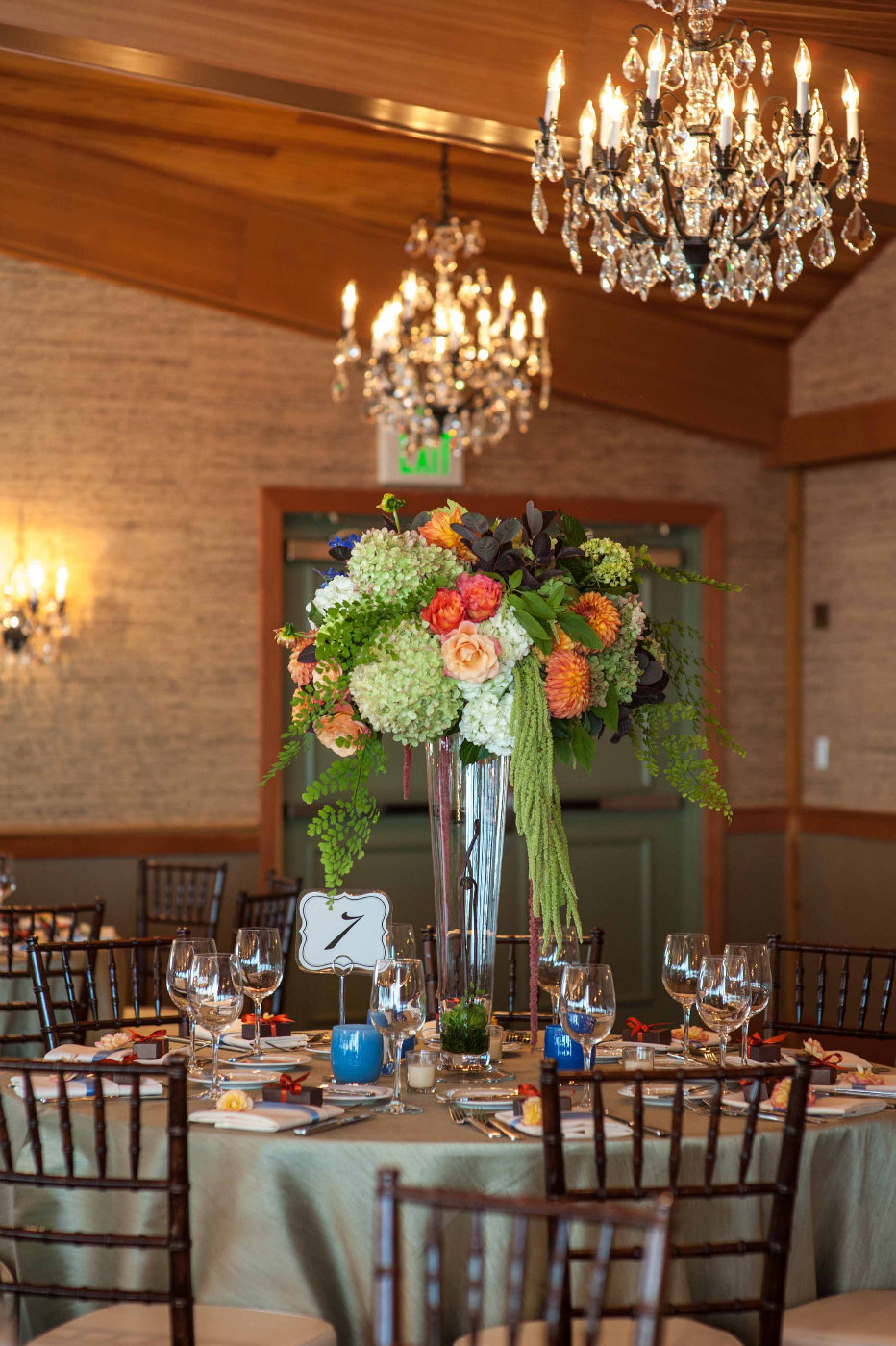 elevated fall centerpiece with trailing green amaranthus, ferns, orange roses, and green hydrangea
