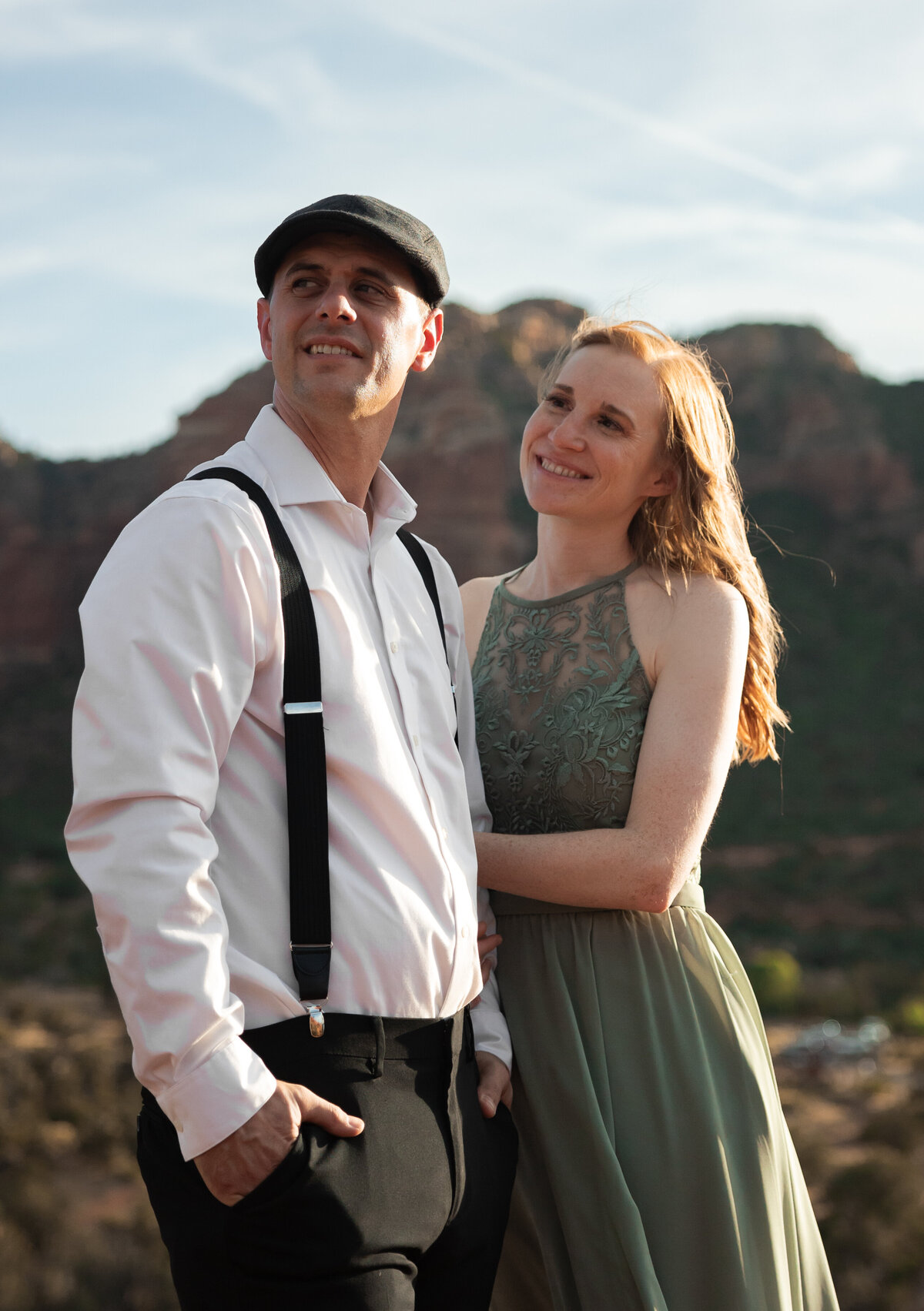 Couple standing against red rock backdrop during Sedona engagement session