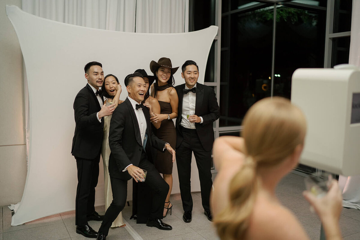Guests at an Aspen Meadows Resort wedding reception pose at a photo booth creating fun and light hearted memories.