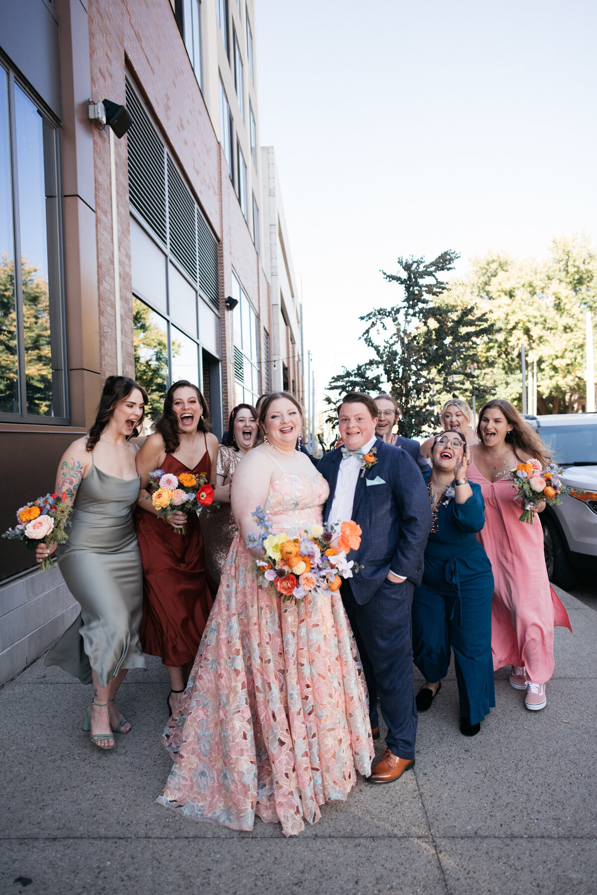 bridesmaids in mismatching bridesmaid dresses and bride wearing colorful wedding dress