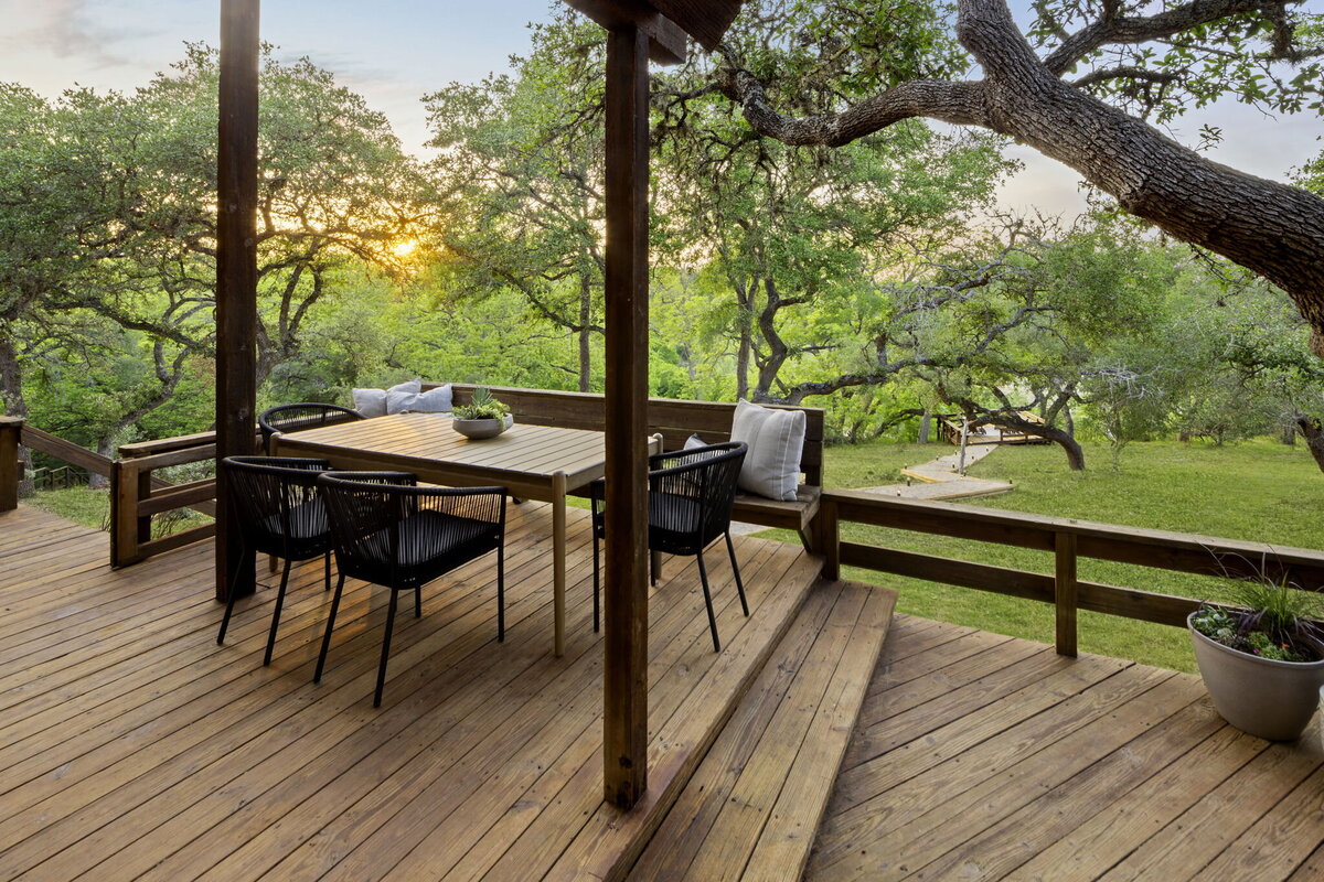 Outside picnic table with  black seats on the wooden deck