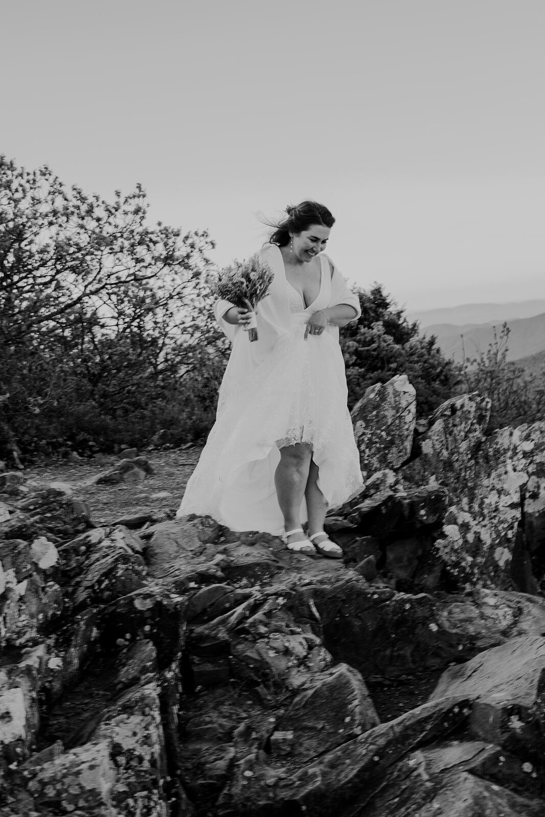 A bride hikes down some rocks to get ready for photos