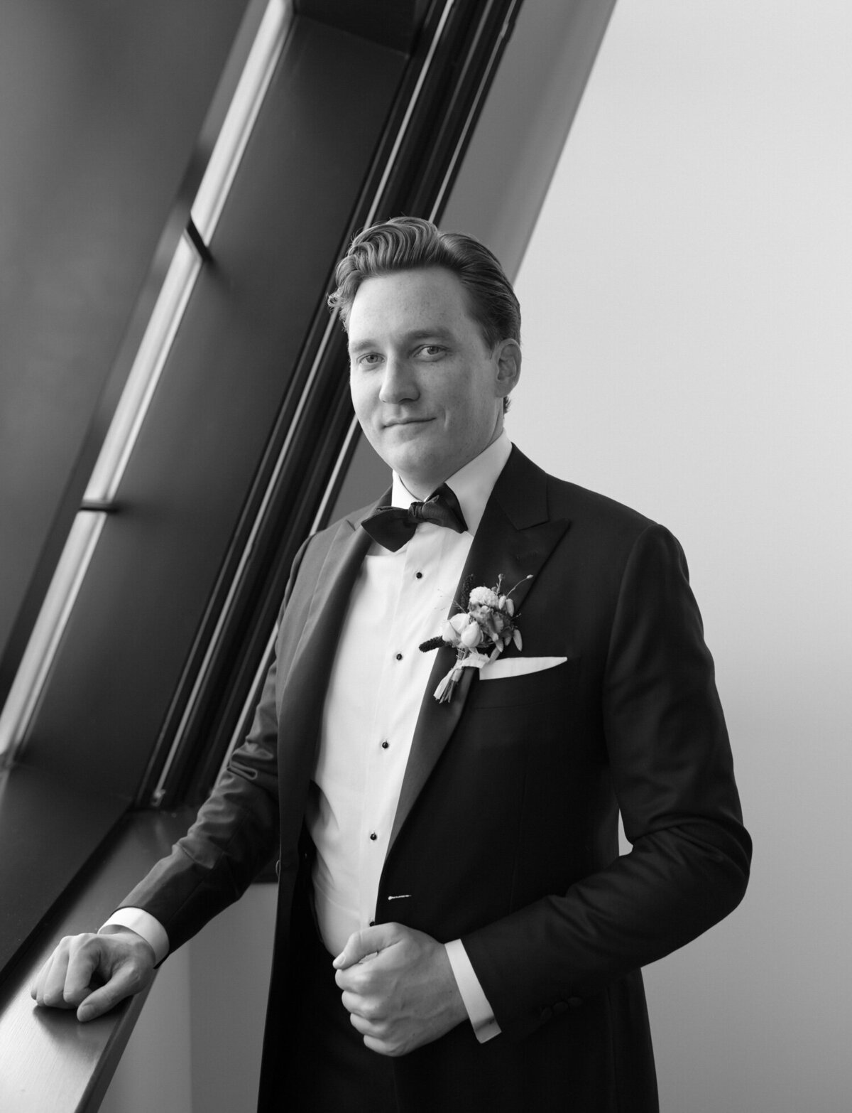 A handsome groom gazes at the camera from his wedding suite at Shinola Hotel, Detroit