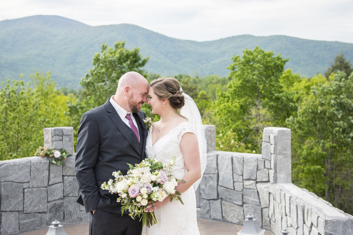 Couple snuggling with mountains behind at Something Blue wedding venue