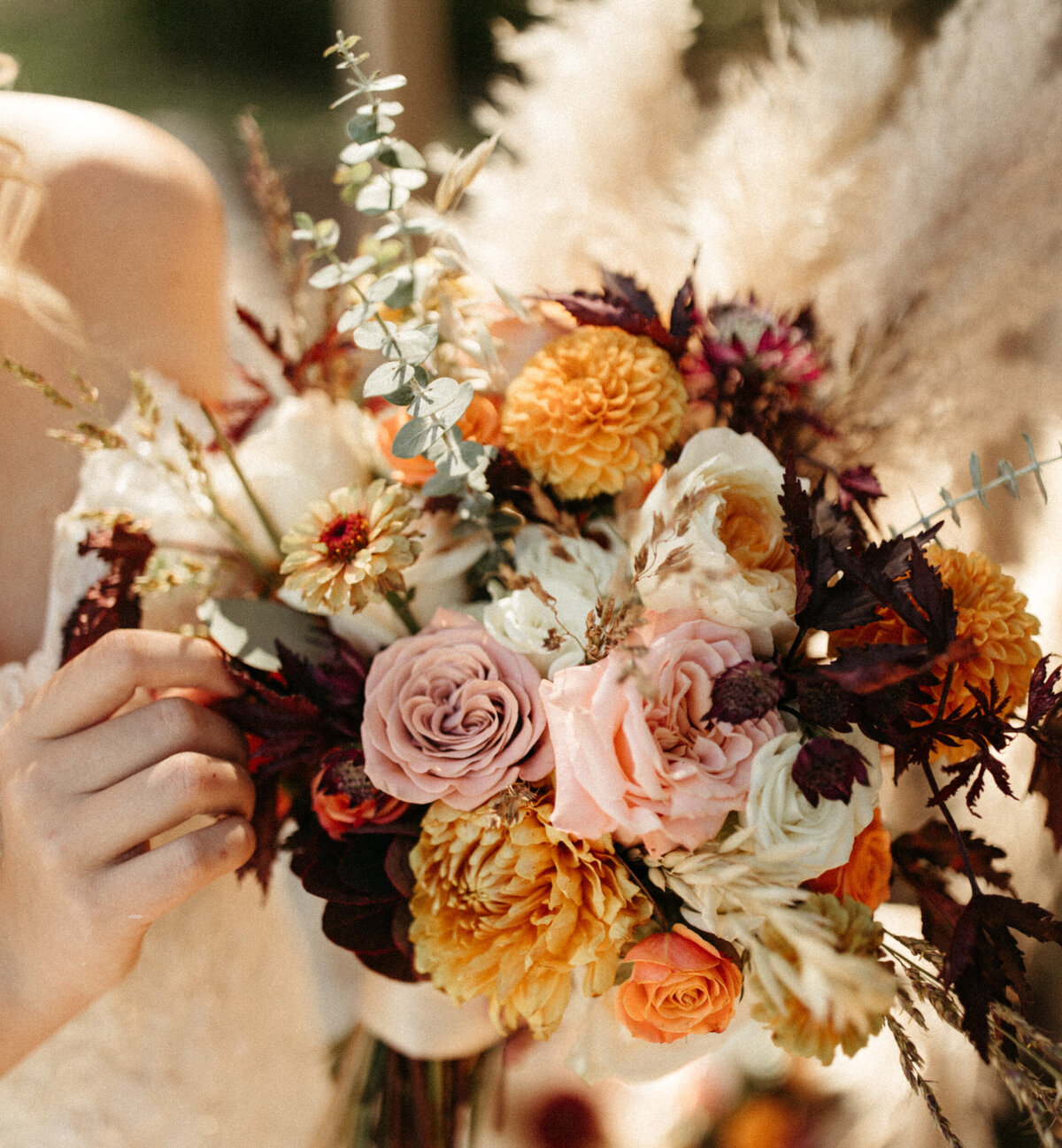 Fall bridal bouquet with pampas grass and assorted warm colored roses