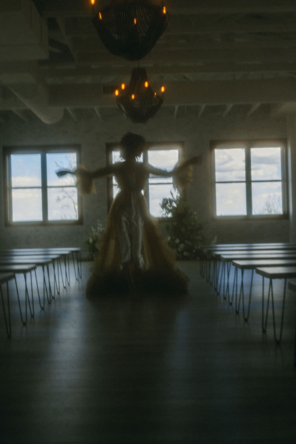 A person in a wedding dress walking down an empty aisle.