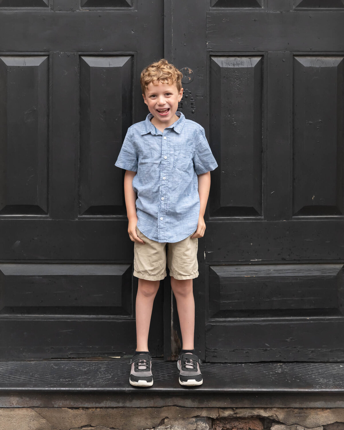 super cute big bro in front of a v;ack doorway downtown