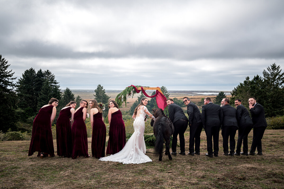 A lighthearted moment with the bridal party playfully showing their fun side alongside the bride's pony at the picturesque North Coast Hitching Post. A perfect blend of humor and rustic charm to celebrate the big day!