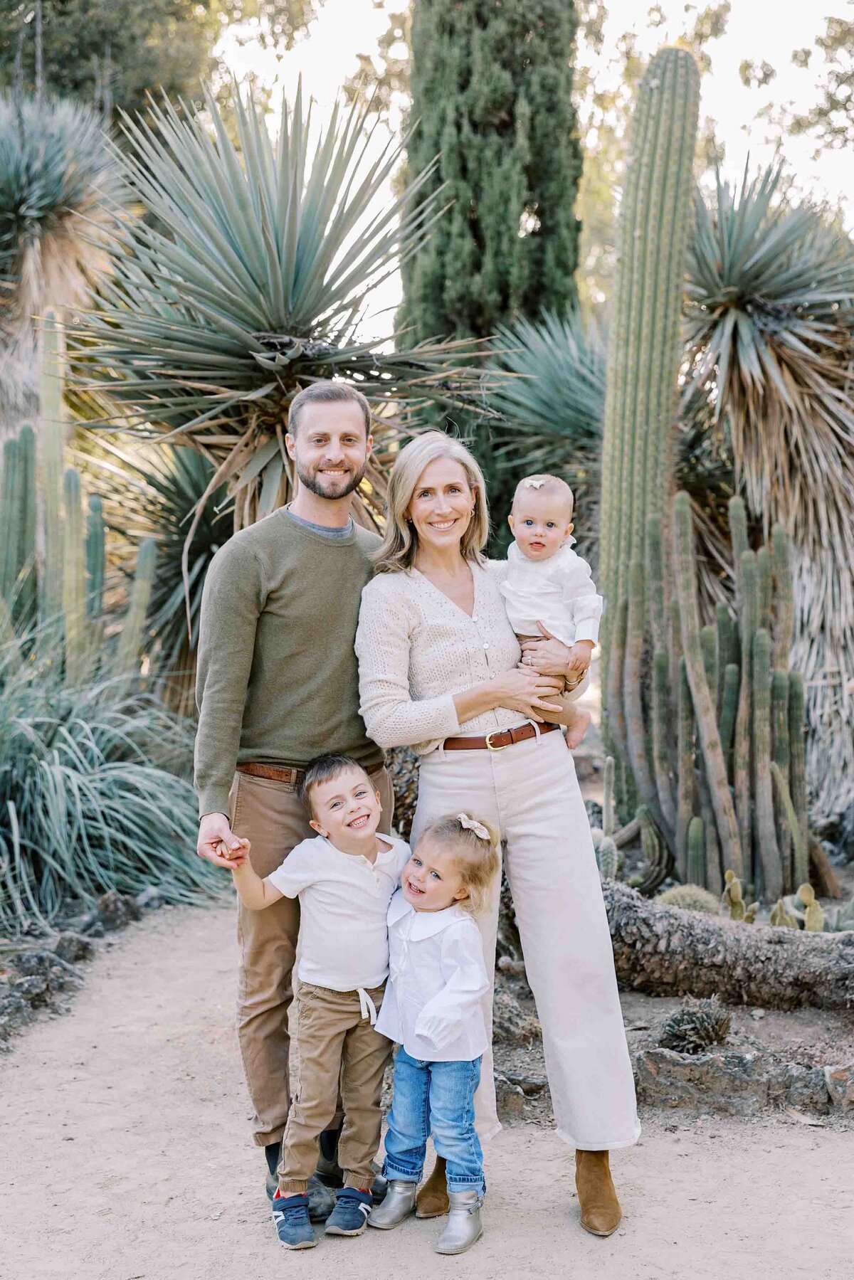 family of 5 standing and smiling at arizona cactus garden
