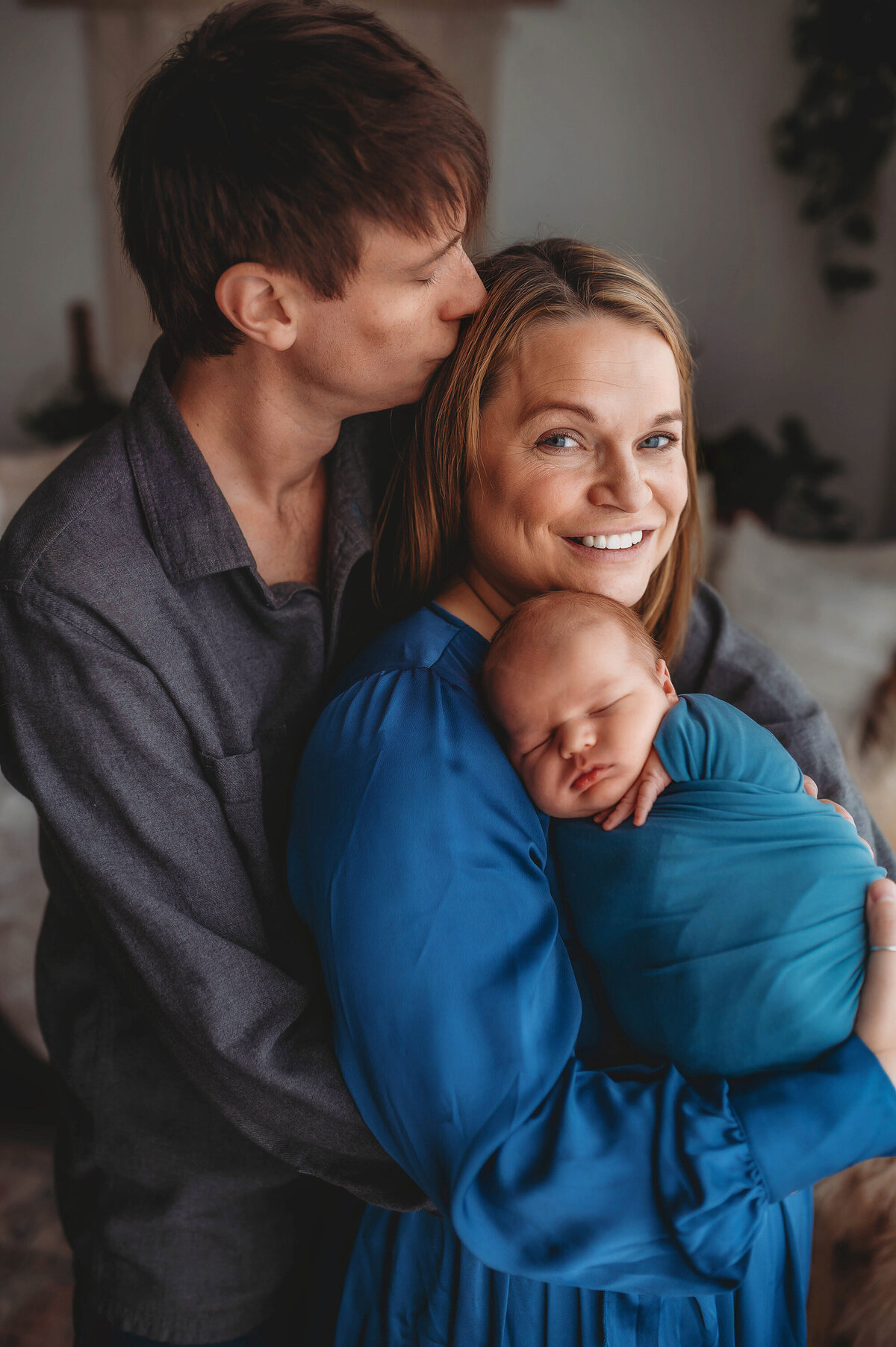 New parents embrace their infant during Newborn Photoshoot in Charleston.