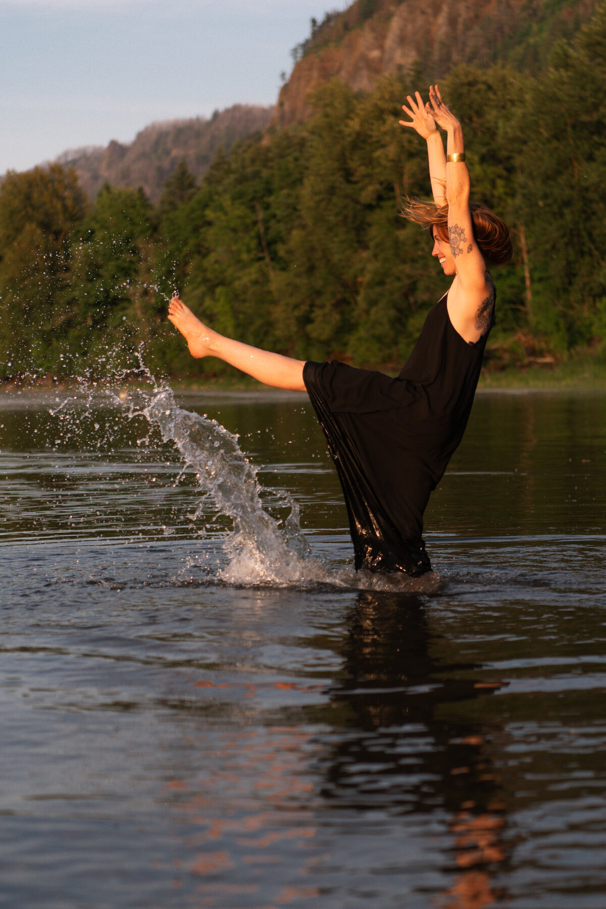 yoga teacher playfully splashing in river water