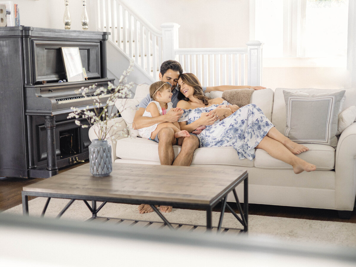 Wide shot of the family gathered in the living room during their newborn session.