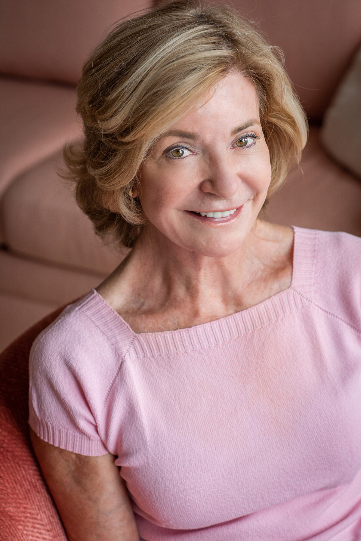 An older woman sitting down and smiling