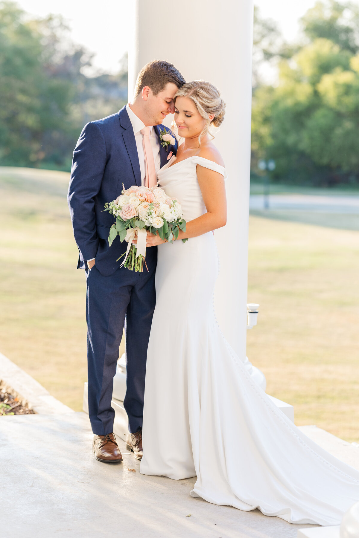 A tender wedding moment captured at sunset in Aubrey, Texas. The bride and groom share an intimate embrace on a veranda, bathed in golden light—perfect for a soft, romantic wedding gallery.