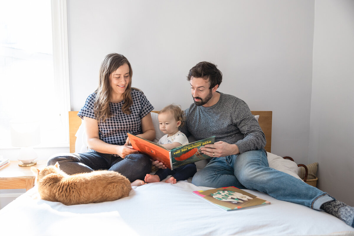 Family reads in bed at home