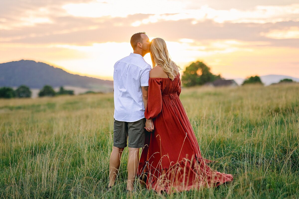 Maternity session in Harrisonburg.  Mom in red dress in a field at sunset