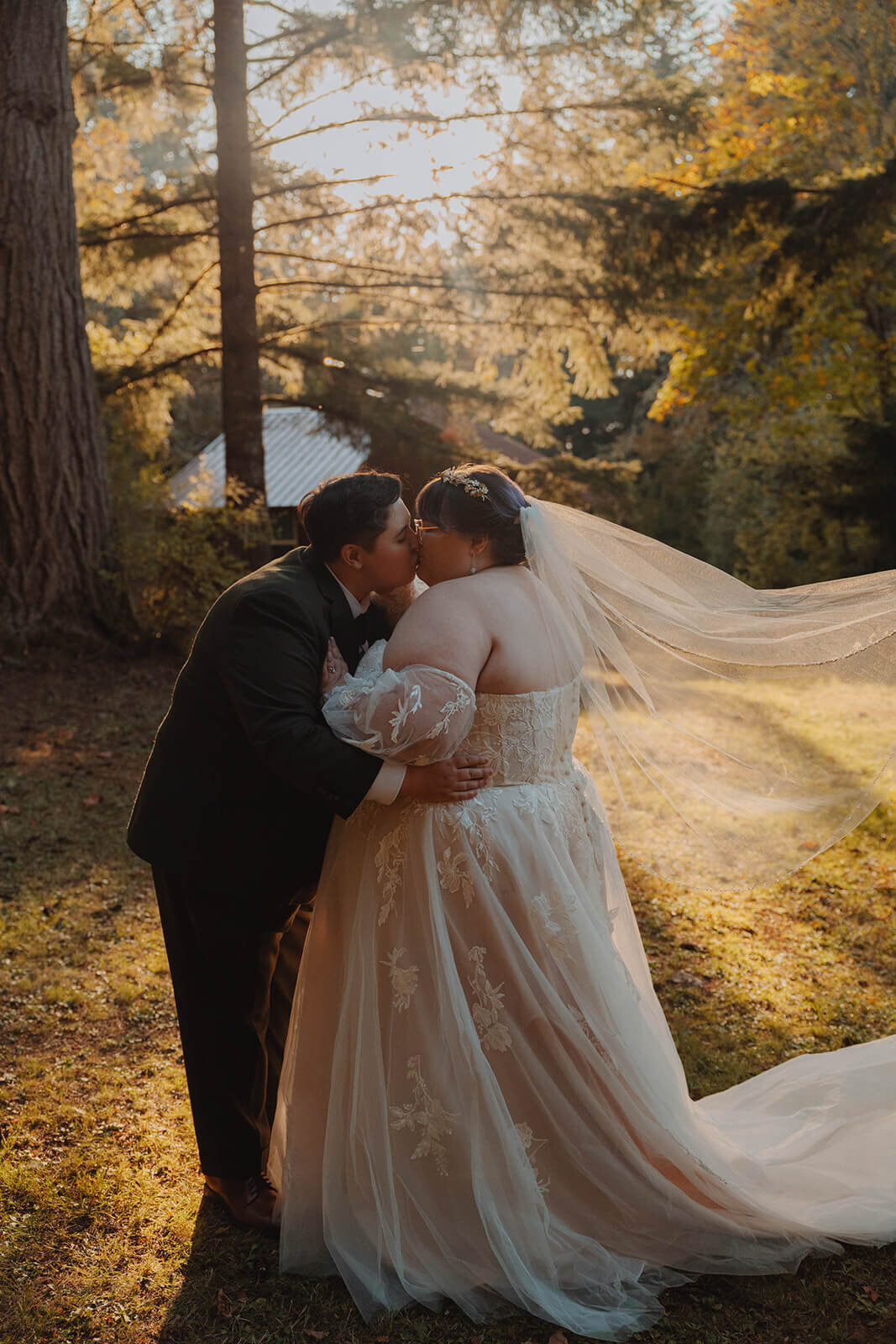 Bride embrace and kiss with the lake and trees in the background at Sky Camp Oregon.