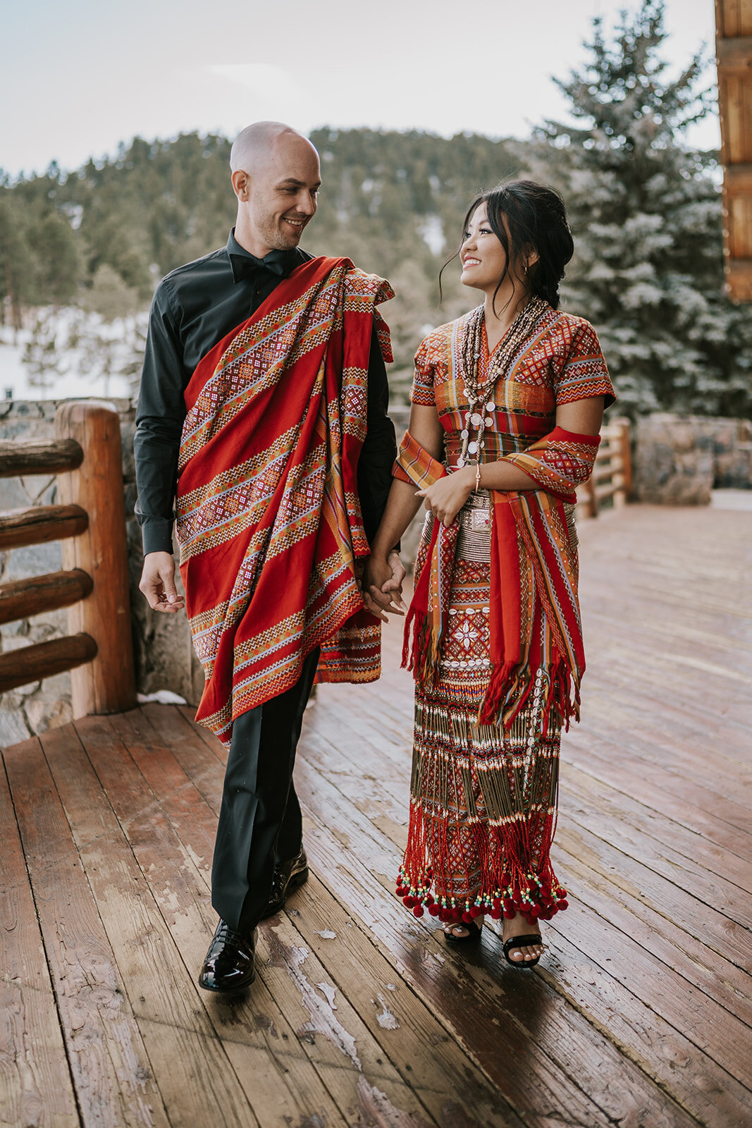 Bride and groom pose in traditional southeast Asian wedding attire.